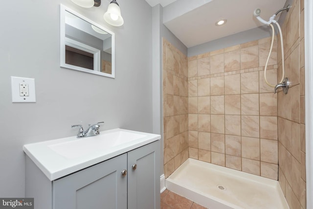 bathroom featuring vanity, tile patterned floors, and tiled shower