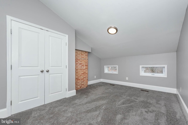 additional living space with lofted ceiling and dark carpet