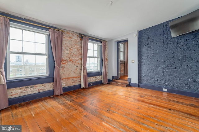 unfurnished room with hardwood / wood-style floors and vaulted ceiling