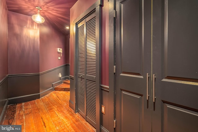 corridor with hardwood / wood-style flooring