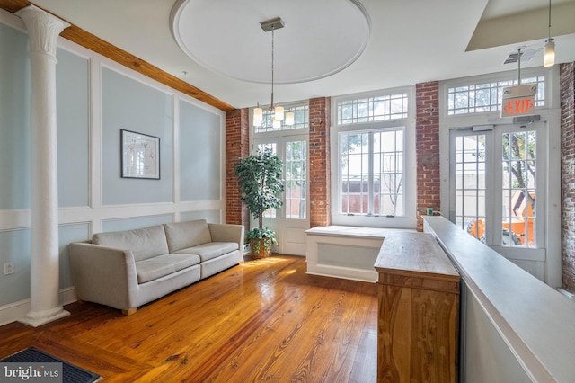 interior space with a healthy amount of sunlight, light wood-type flooring, and brick wall