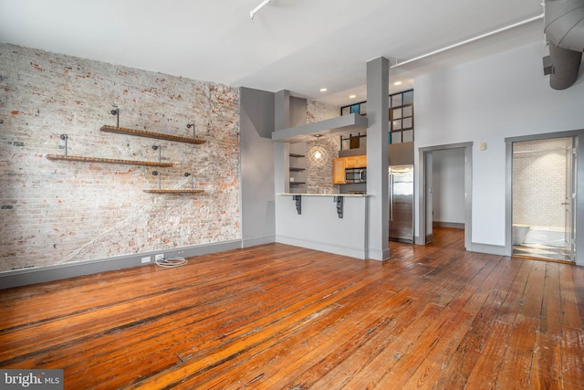 unfurnished living room with hardwood / wood-style flooring and a high ceiling