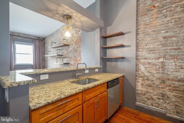 kitchen featuring light stone countertops, dark wood-type flooring, sink, pendant lighting, and dishwasher