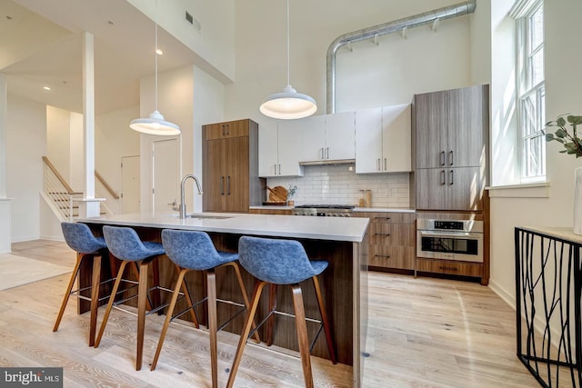 kitchen featuring oven, sink, plenty of natural light, and light hardwood / wood-style floors