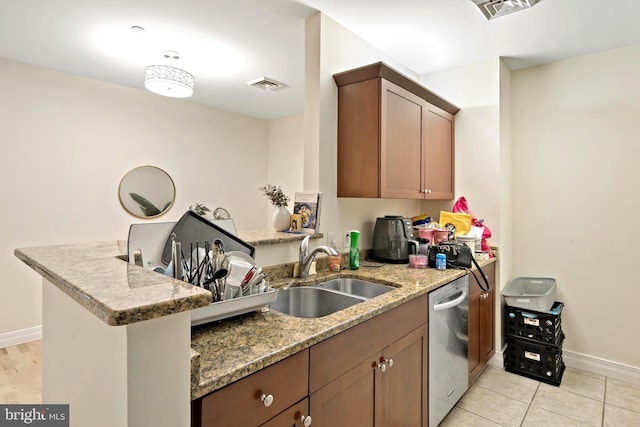 kitchen featuring kitchen peninsula, sink, dishwasher, light stone counters, and light tile patterned floors