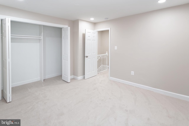 unfurnished bedroom featuring a closet and light carpet