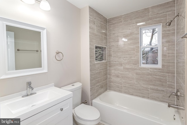 full bathroom with vanity, tiled shower / bath combo, and toilet