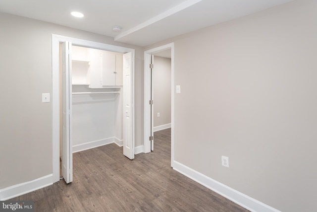 unfurnished bedroom featuring dark hardwood / wood-style floors and a closet