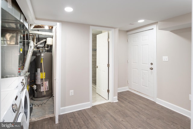 basement with hardwood / wood-style flooring, gas water heater, and washer and dryer