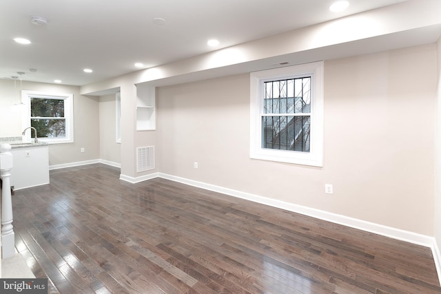 basement featuring sink and dark hardwood / wood-style floors