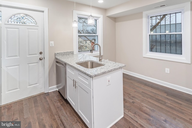 kitchen featuring decorative light fixtures, white cabinetry, sink, stainless steel dishwasher, and light stone counters