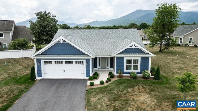 view of front of property featuring a mountain view, a garage, and a front lawn