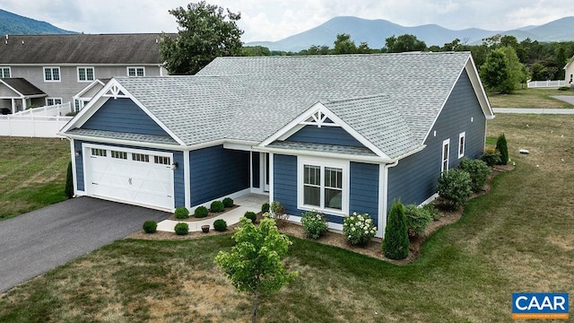 view of front of home with a mountain view, a garage, and a front yard