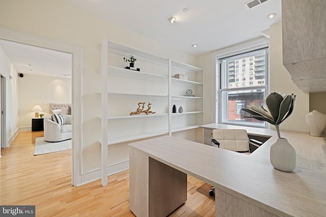 home office with light hardwood / wood-style flooring