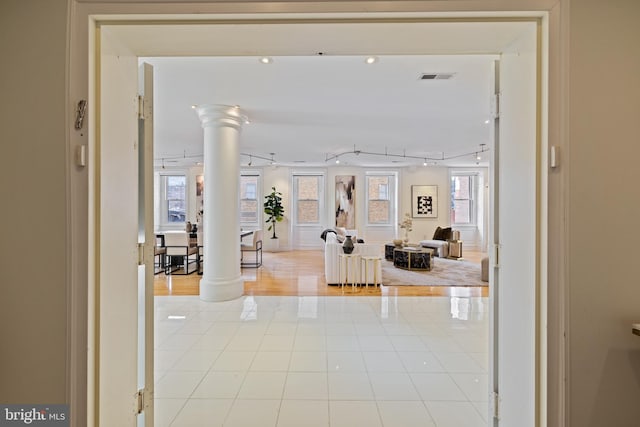 hallway featuring decorative columns and light wood-type flooring