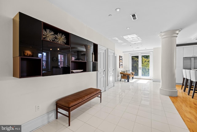 corridor featuring ornate columns, hardwood / wood-style floors, and french doors