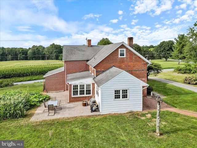 rear view of property with a patio and a lawn