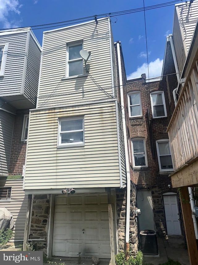 exterior space with central AC and a garage