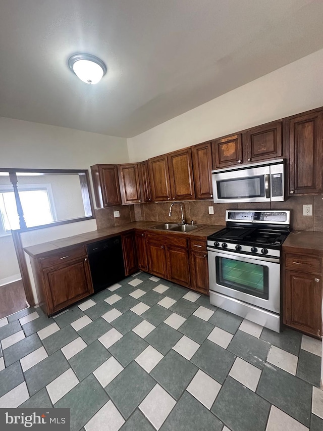 kitchen featuring stainless steel appliances, tasteful backsplash, and sink