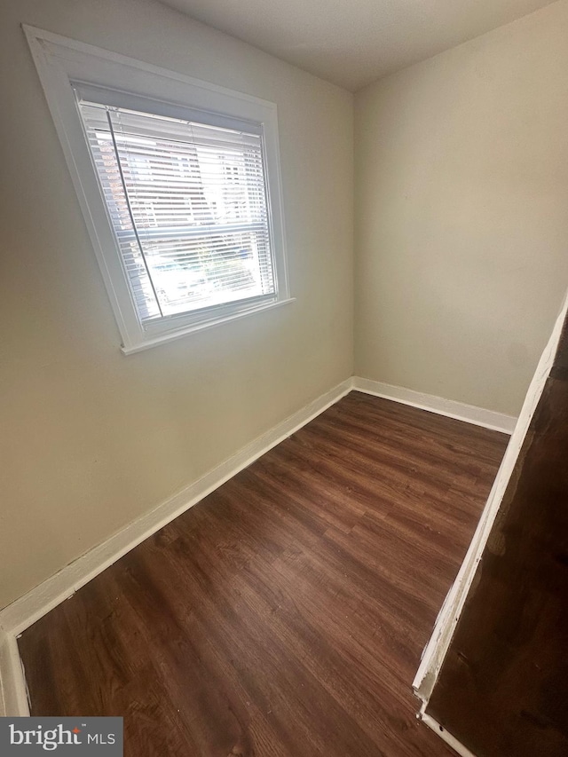 spare room featuring dark wood-type flooring