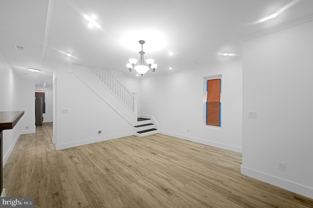 unfurnished living room with a chandelier and light hardwood / wood-style floors