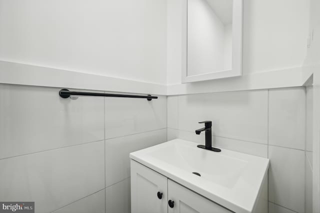 bathroom featuring vanity and tile walls