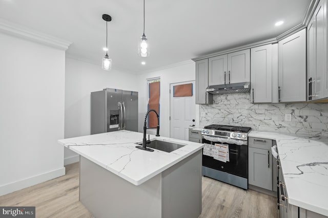 kitchen featuring sink, hanging light fixtures, a kitchen island with sink, stainless steel appliances, and light stone countertops