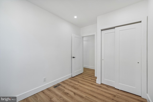 unfurnished bedroom featuring a closet and light hardwood / wood-style flooring