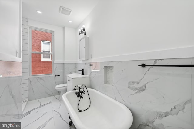 bathroom featuring vanity, a washtub, tile walls, and toilet