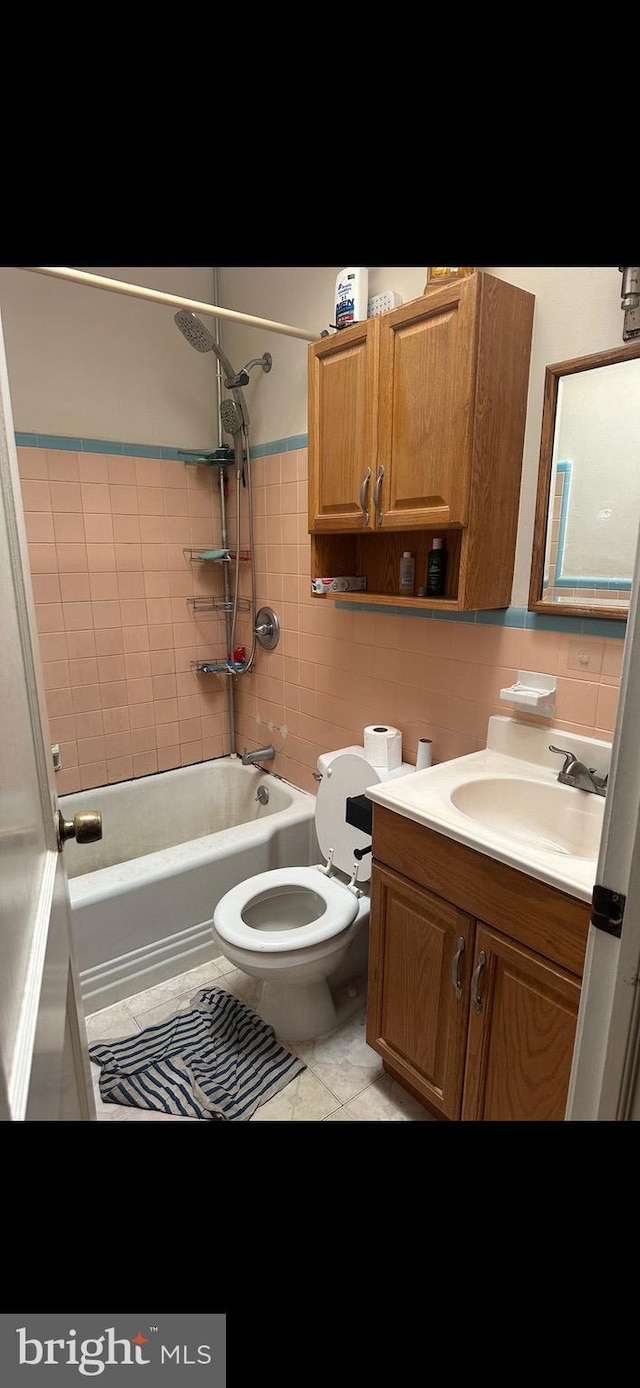 full bathroom featuring vanity, tile patterned floors, tiled shower / bath, decorative backsplash, and toilet