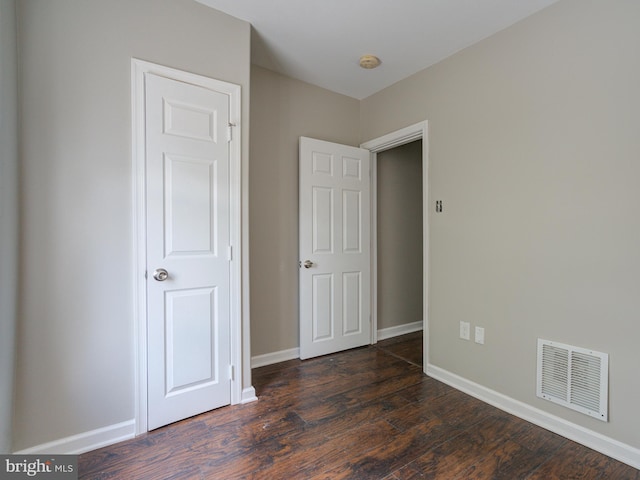 unfurnished bedroom featuring dark hardwood / wood-style flooring