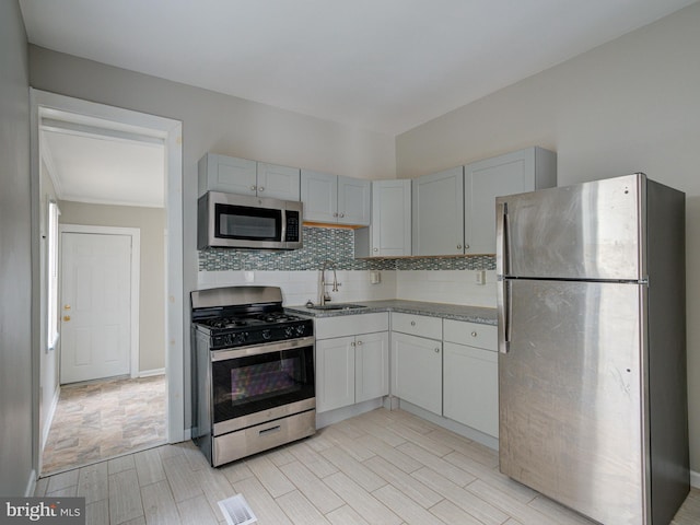 kitchen with light tile patterned flooring, decorative backsplash, stainless steel appliances, and sink