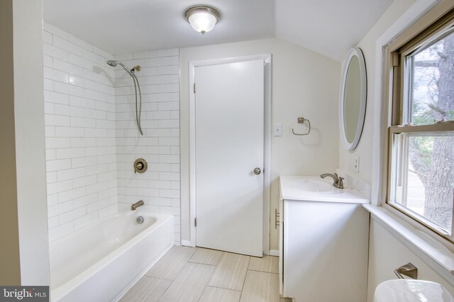 bathroom featuring tiled shower / bath and vanity