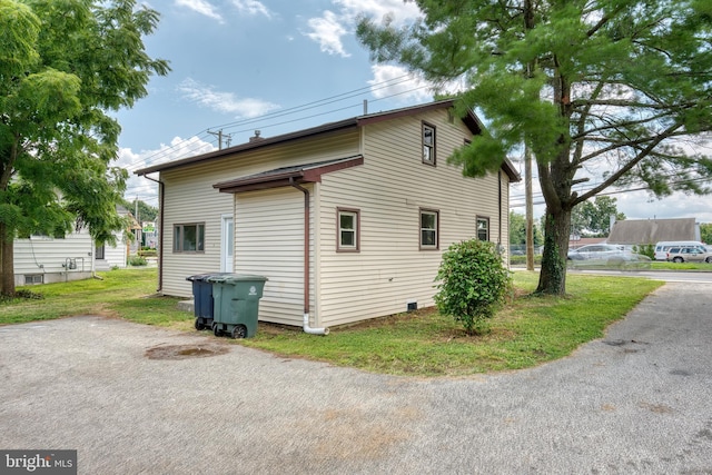 view of side of home with a yard