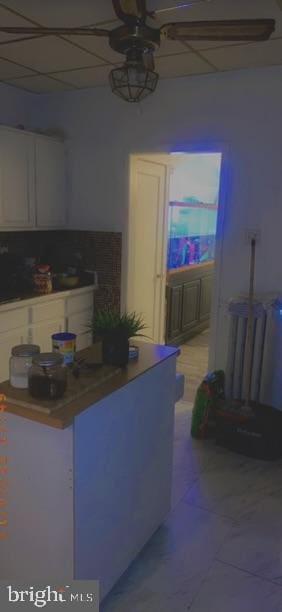 kitchen with white cabinets, light tile patterned floors, and ceiling fan