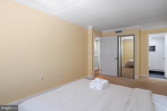 bedroom with a textured ceiling, ornamental molding, light carpet, and ensuite bathroom