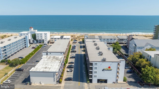 birds eye view of property with a water view and a beach view