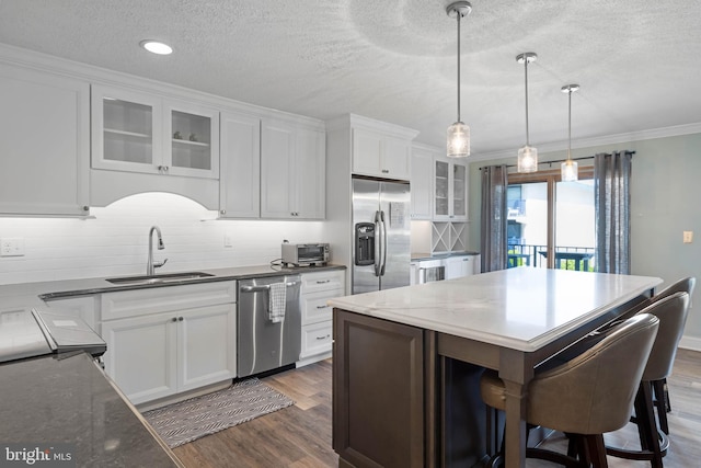 kitchen with a center island, sink, white cabinetry, decorative backsplash, and stainless steel appliances