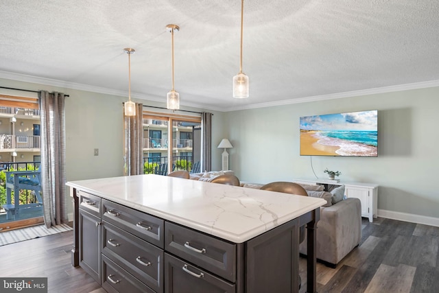 kitchen with dark wood-type flooring, a kitchen bar, decorative light fixtures, and crown molding