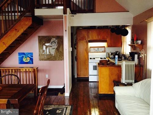 kitchen with lofted ceiling, dark hardwood / wood-style flooring, radiator, and white gas range oven