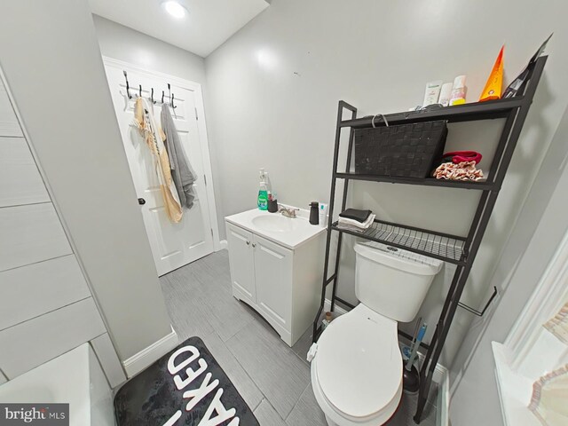 bathroom with wood-type flooring, vanity, and toilet