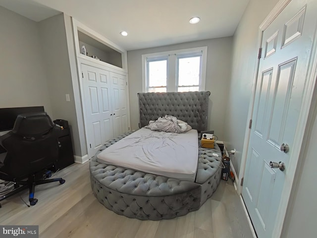 bedroom with light wood-type flooring and a closet