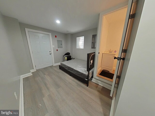 bedroom featuring electric panel and light wood-type flooring