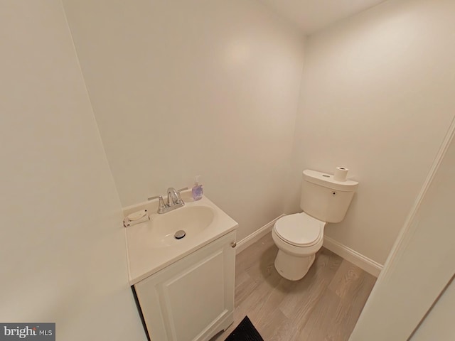 bathroom with wood-type flooring, vanity, and toilet