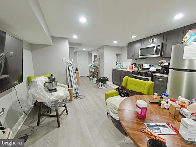 kitchen featuring gray cabinetry, stainless steel appliances, light wood-type flooring, and sink