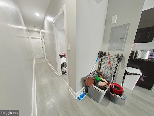 hallway featuring electric panel and light hardwood / wood-style flooring