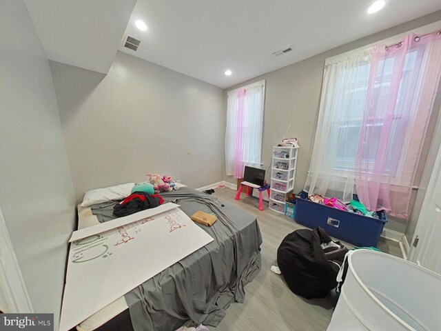 bedroom featuring light wood-type flooring and multiple windows