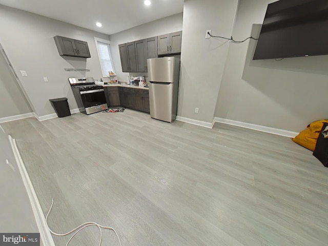 kitchen with gray cabinetry, appliances with stainless steel finishes, and light hardwood / wood-style flooring