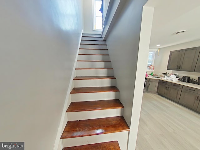 staircase with a wealth of natural light and wood-type flooring