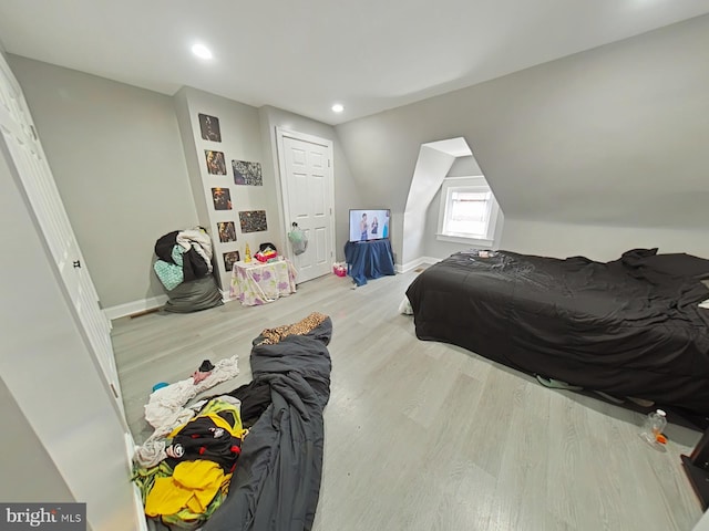 bedroom with lofted ceiling and light hardwood / wood-style floors